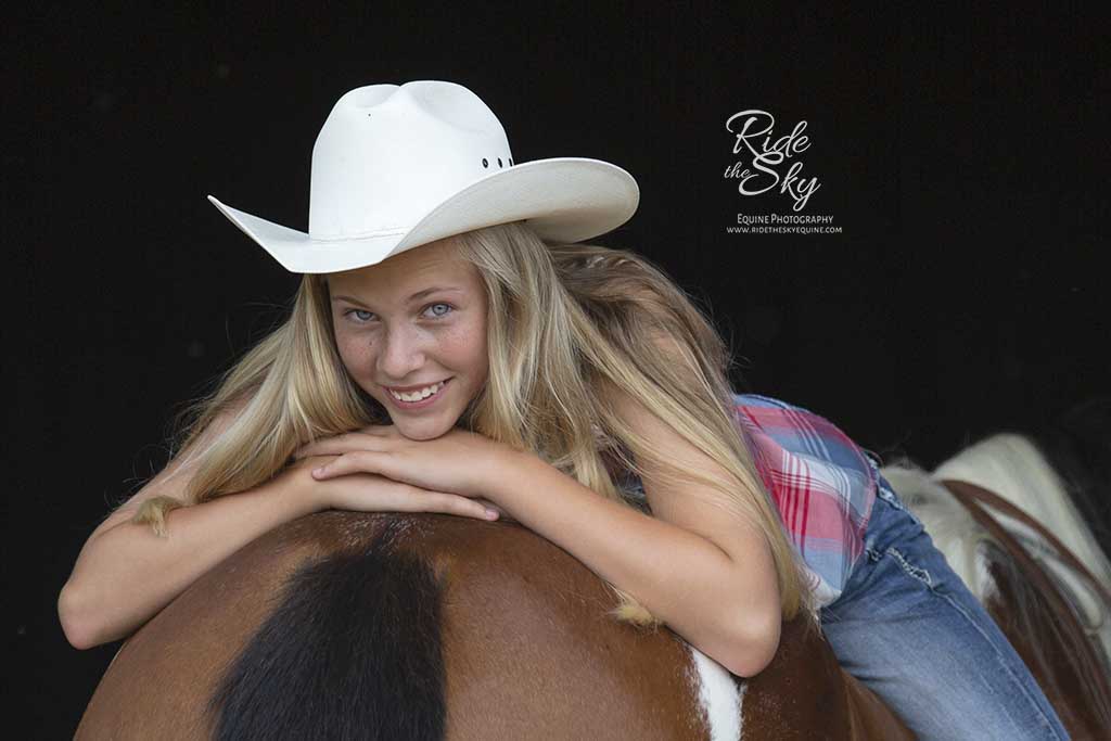 Black Background Photograph of Cowgirl posed on her paint horse from the image portfolio of Ride the Sky Equine Photography