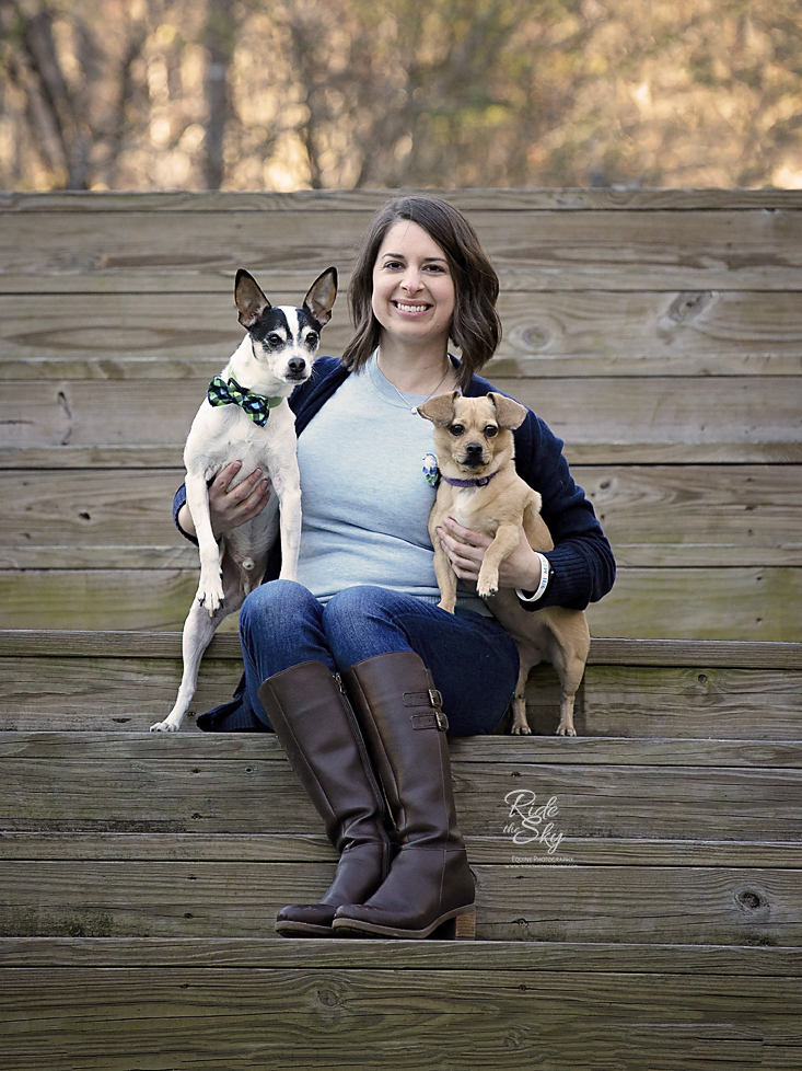 Woman posed with two dogs on wooden steps