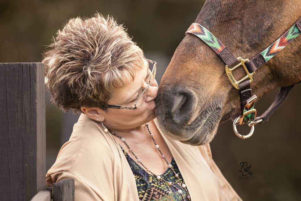 Woman kissing horse muzzle