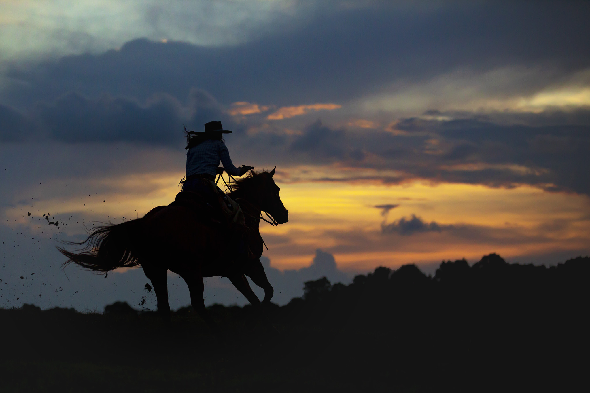 Commercial Equestrian Lifestyle image of cowgirl riding horse at sunset