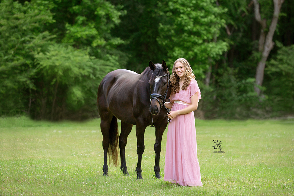 Girl in pink dress with thoroughbred horse