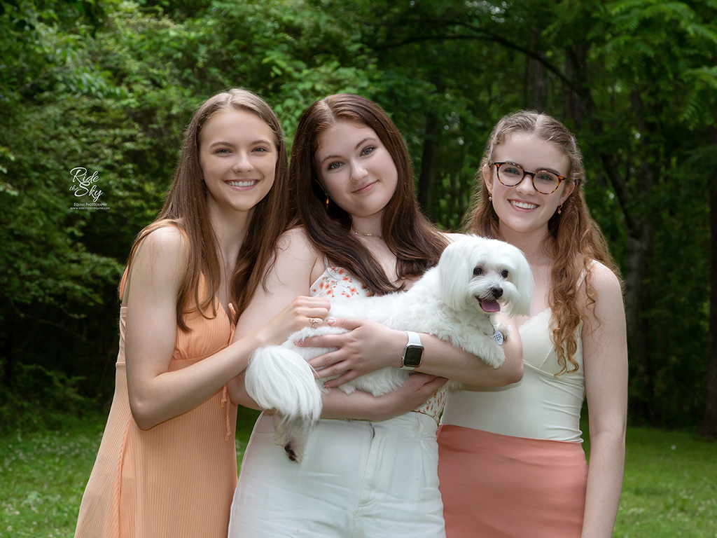 Three teenage girls holding white dog in Enterprise South Nature park