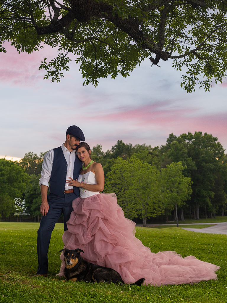 Woman in fancy dress hugging man in suit with dog at their feet at Kensington Cove Farm in Chickkamauga GA