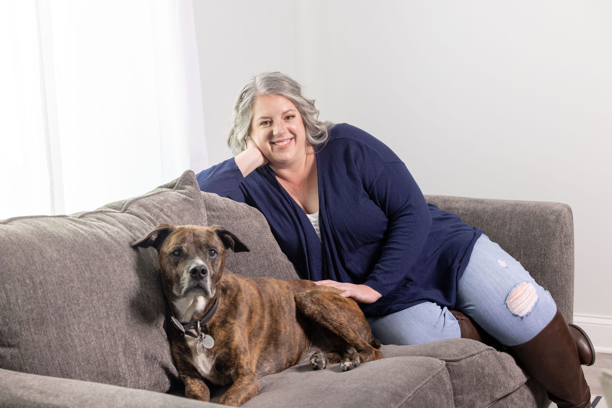 Betsy Bird, and her dog, Nitro posed on couch. Betsy is a horse and pet photographer in Tennessee