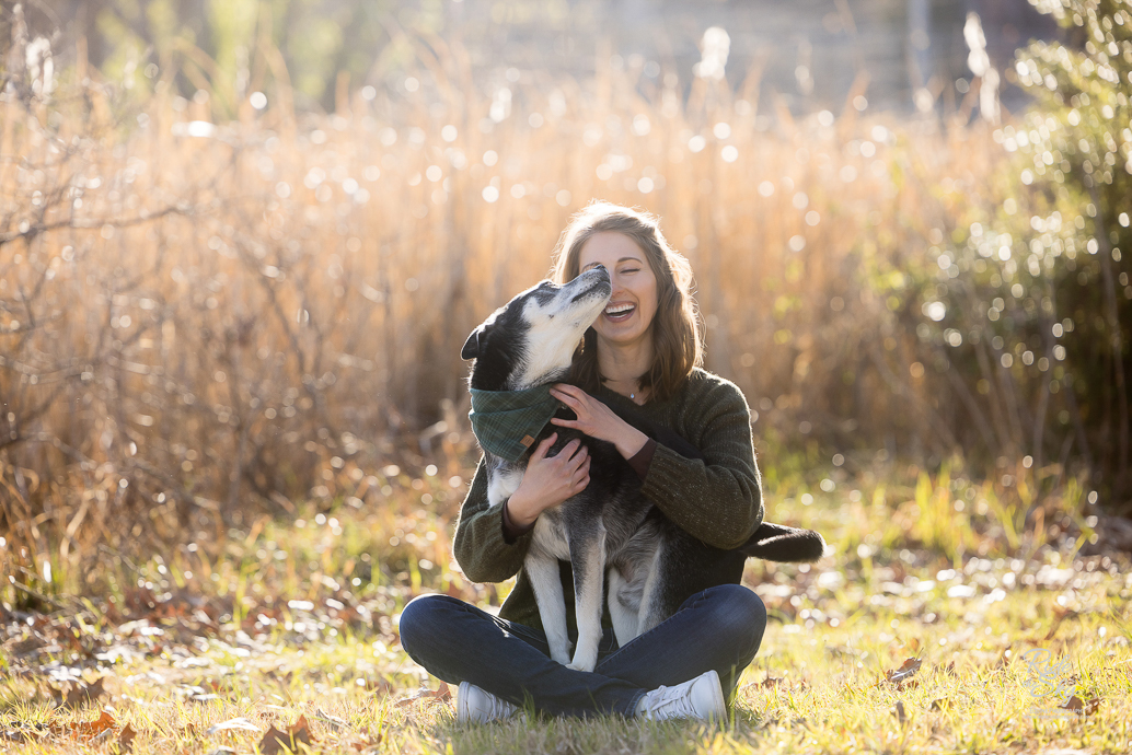 Woman and her dog sitting in field