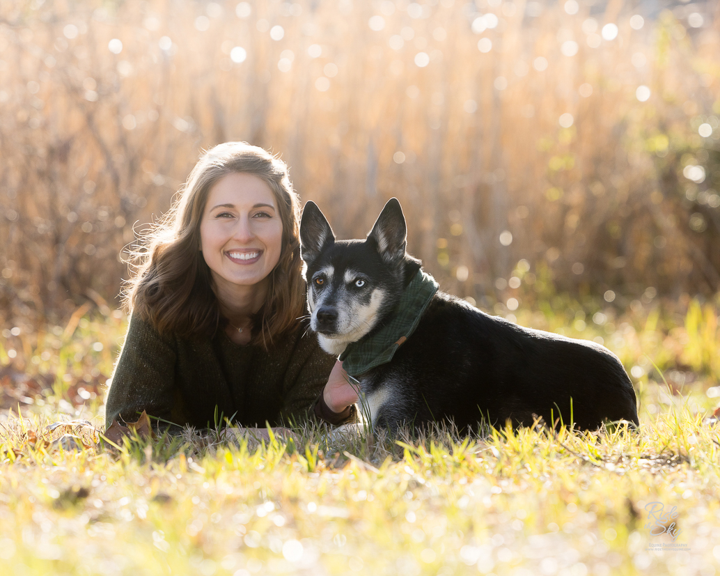 women and her dog with 2 different color eyes laying in a field at Chester Frost Park in Hixson, Tennessee