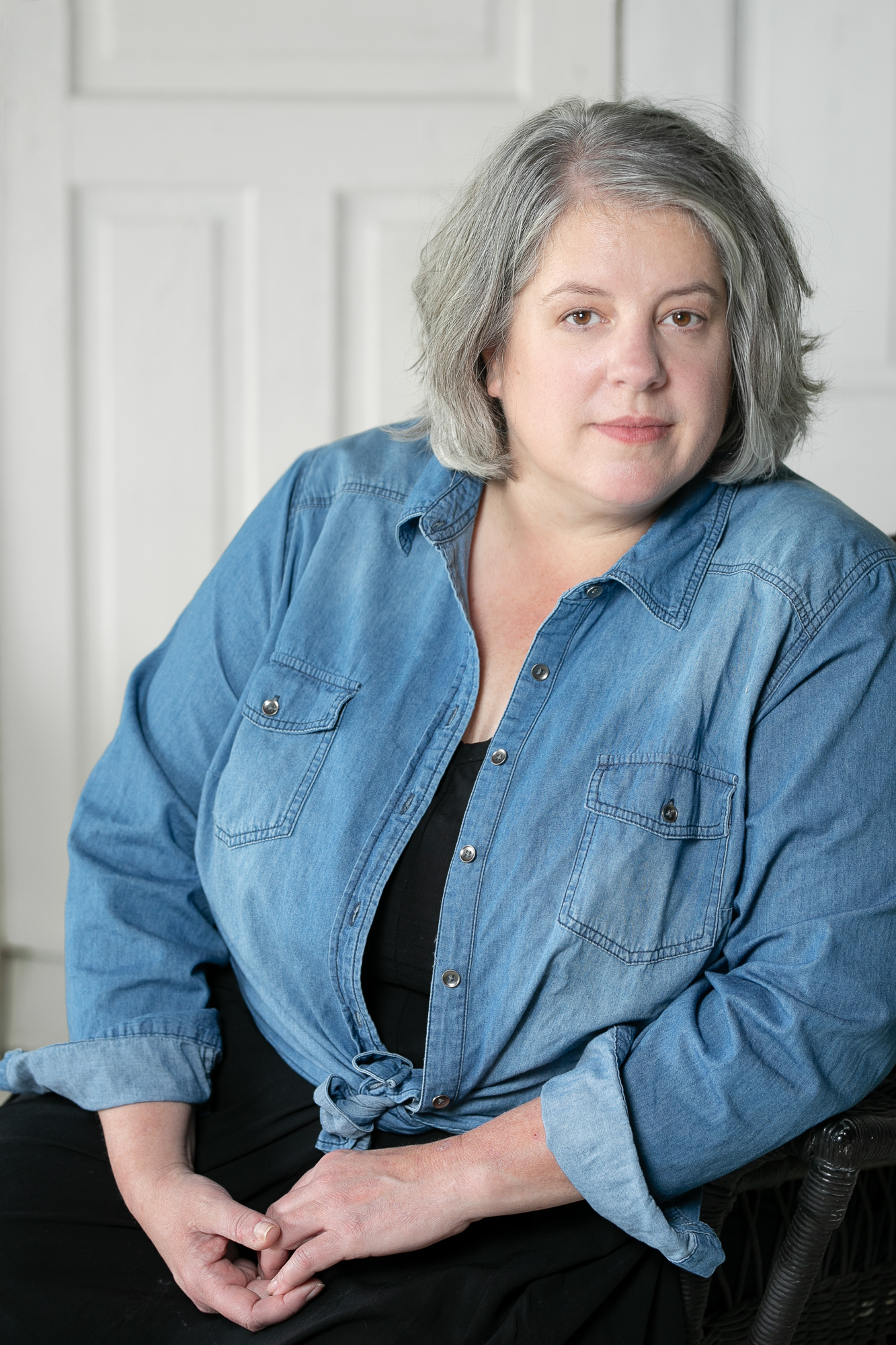 Betsy Bird, President of the Professional Photographers of East Tennessee and owner of Ride the Sky Equine Photography sitting in a chair. 